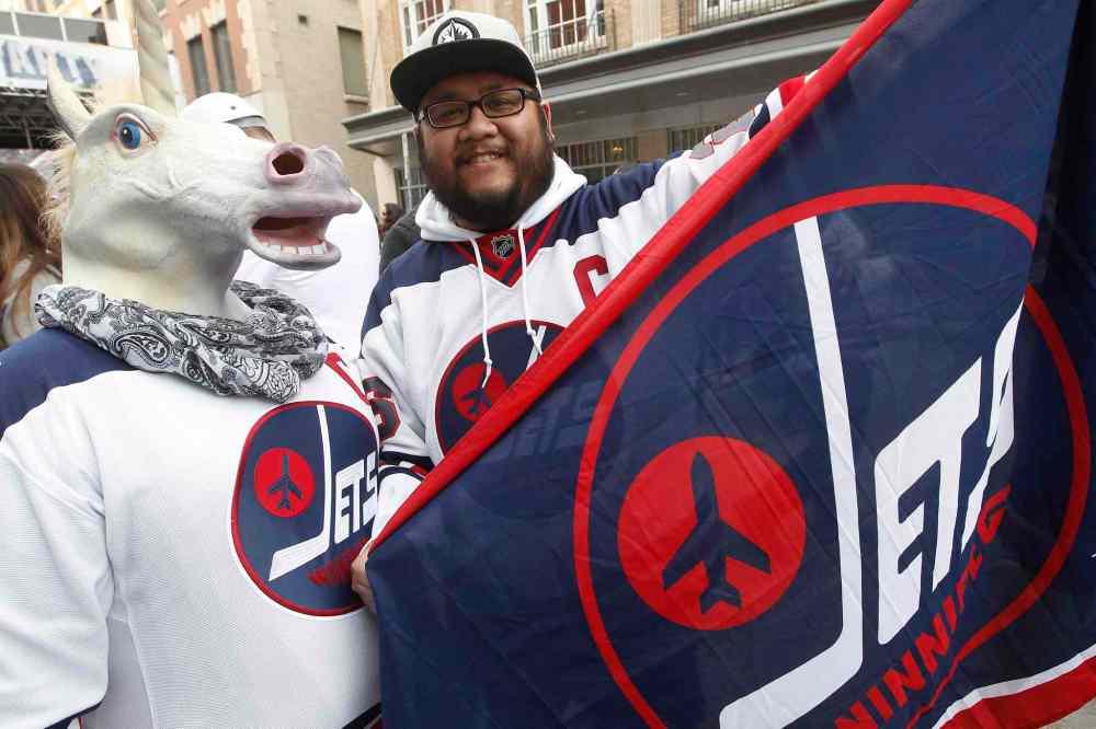 JOHN WOODS / THE CANADIAN PRESS
Brittany Moore and Lester Pineda get in the playoff spirit at the Winnipeg Jets White Out Street Party prior to game one of the playoff series against Minnesota Wild Wednesday, April 11, 2018.