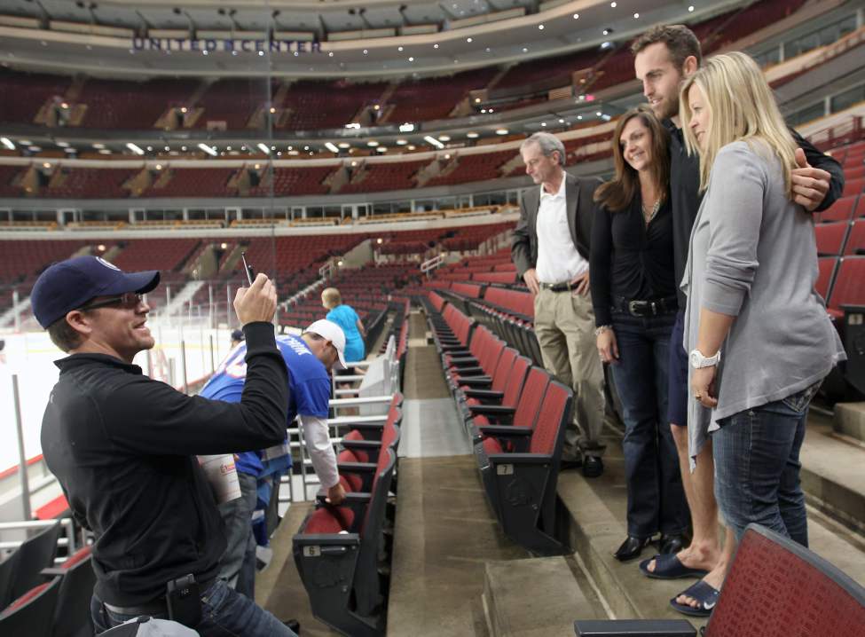 John McDonald takes a picture of Kristen McDonald, left, Jets Captain Andrew Ladd, centre, and Monica Kidieux in the United Center just prior to the Jets morning skate Thursday in Chicago. (JOE BRYKSA / WINNIPEG FREE PRESS)