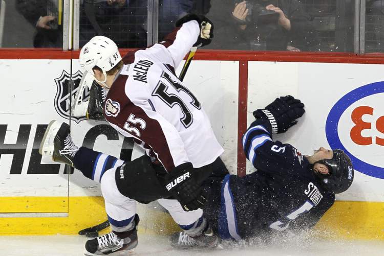 John Woods / Winnipeg Free Press
Winnipeg Jets' Mark Stuart (5) crashes hard into the boards after being taken down by Colorado Avalanche's Cody McLeod (55).