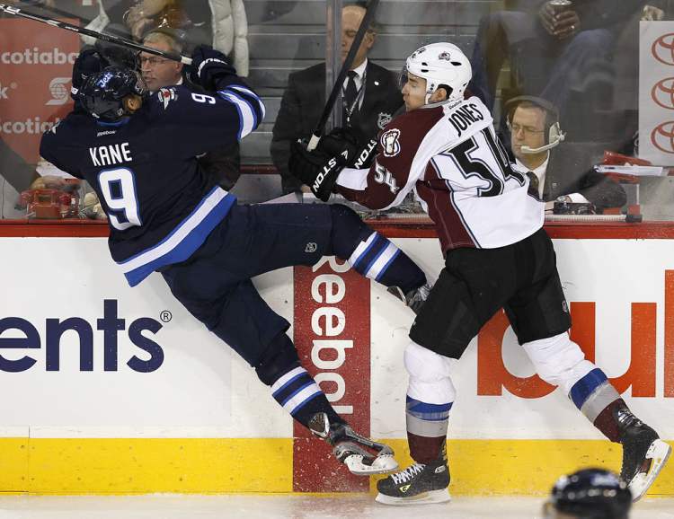 John Woods / Winnipeg Free Press
Winnipeg Jets' Evander Kane (9) is checked hard by Colorado Avalanche's David Jones (54) during first period NHL action in Winnipeg on Sunday.