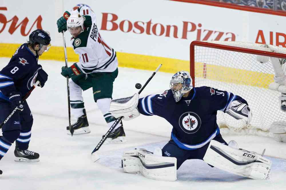 JOHN WOODS / WINNIPEG FREE PRESS
Winnipeg Jets goaltender Ondrej Pavelec (31) gets his stick on the shot as Jacob Trouba (8) defends and Minnesota Wild's Zach Parise (11) looks for the rebound during second period NHL action in Winnipeg on Sunday, April 3, 2016.