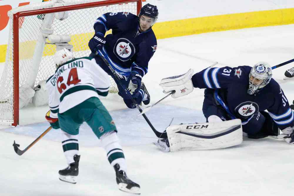 JOHN WOODS / WINNIPEG FREE PRESS
Minnesota Wild's Mikael Granlund (64) shoots to score as Winnipeg Jets' Alex Burmistrov (6) attempts to cover the net when goaltender Ondrej Pavelec (31) gets caught out of position during third period.