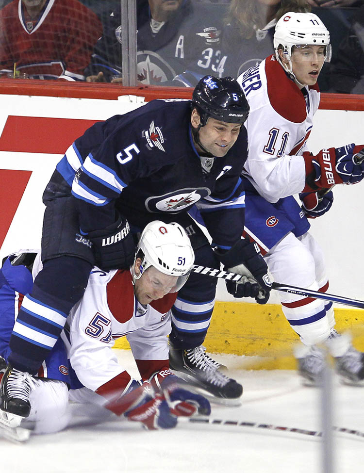 JOHN WOODS / THE CANADIAN PRESS
Winnipeg Jets' Mark Stuart ends up on top of Montreal Canadiens' David Desharnais (51) in the first period Thursday night.