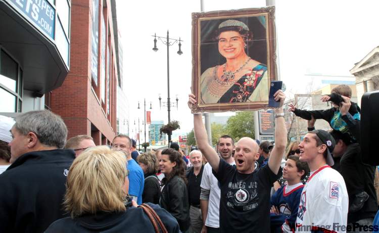 Clinton Brandt carries a replica image of Queen Elizabeth outside the MTS Centre. (Mike Deal / Winnipeg Free Press)