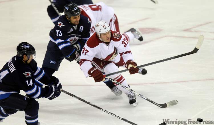 Phil Hossack / Winnipeg Free Press
Dustin Byfuglien holds up Coyote Raffi Torres Thursday at the MTS Centre.