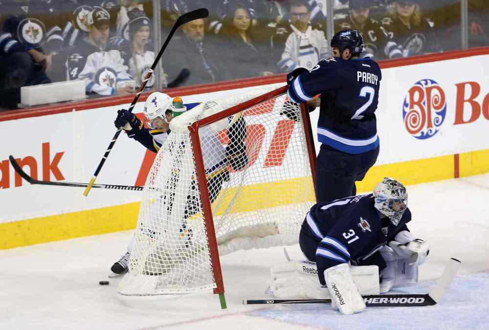 TREVOR HAGAN / WINNIPEG FREE PRESS
The Blues' T.J. Oshie skates behind the net after pushing Jets defenceman Adam Pardy into goalie Ondrej Pavelec during the first period.