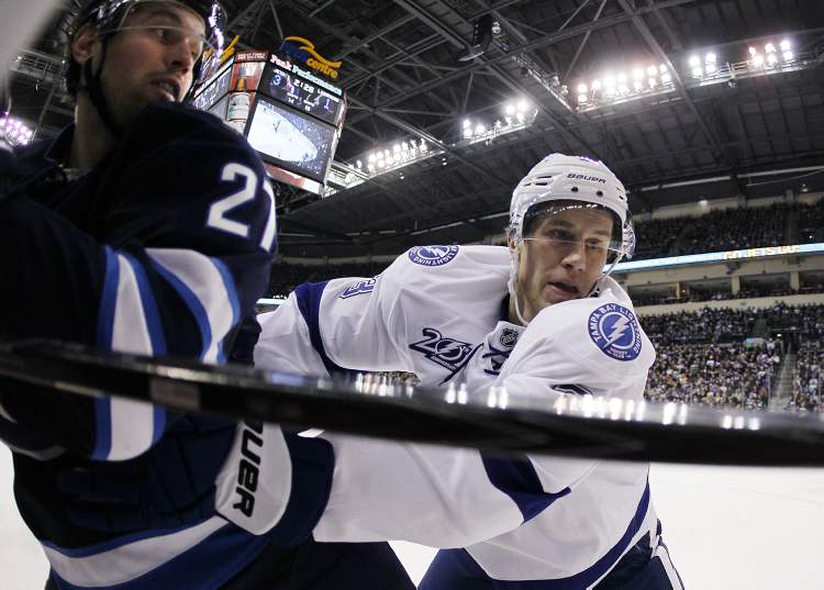 JOHN WOODS / WINNIPEG FREE PRESS
Tampa Bay Lightning's Keith Aulie (right) checks Winnipeg Jets' Eric Tangradi during the second period of an NHL game in Winnipeg on Sunday.