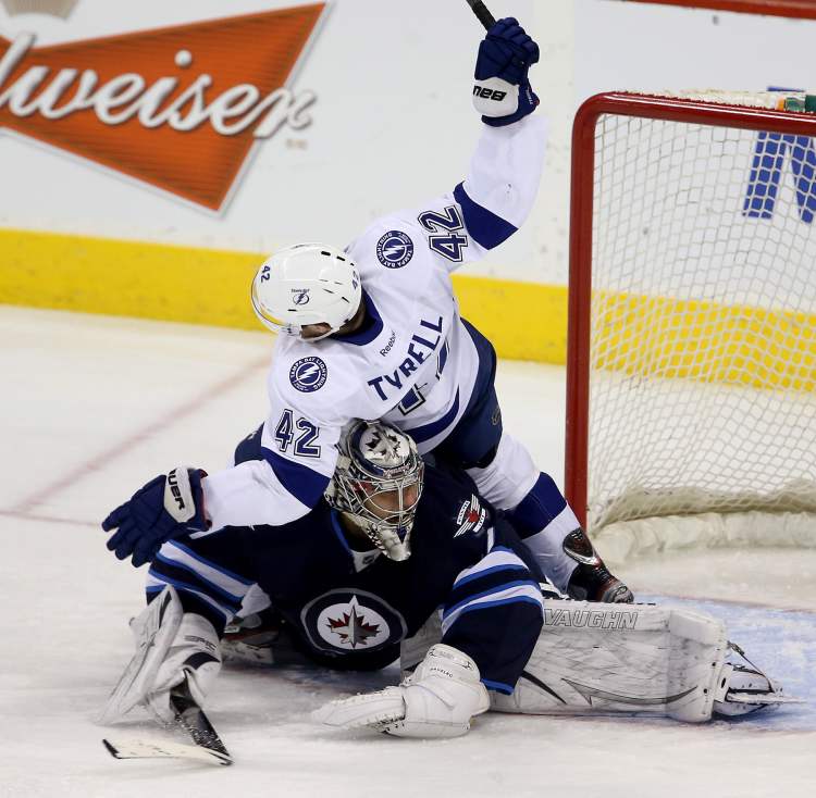 Trevor Hagan / THE CANADIAN PRESS
Tampa Bay Lightnings' Dana Tyrell crashes into Winnipeg Jets goaltender Ondrej Pavelec during the first period in Winnipeg, Sunday.