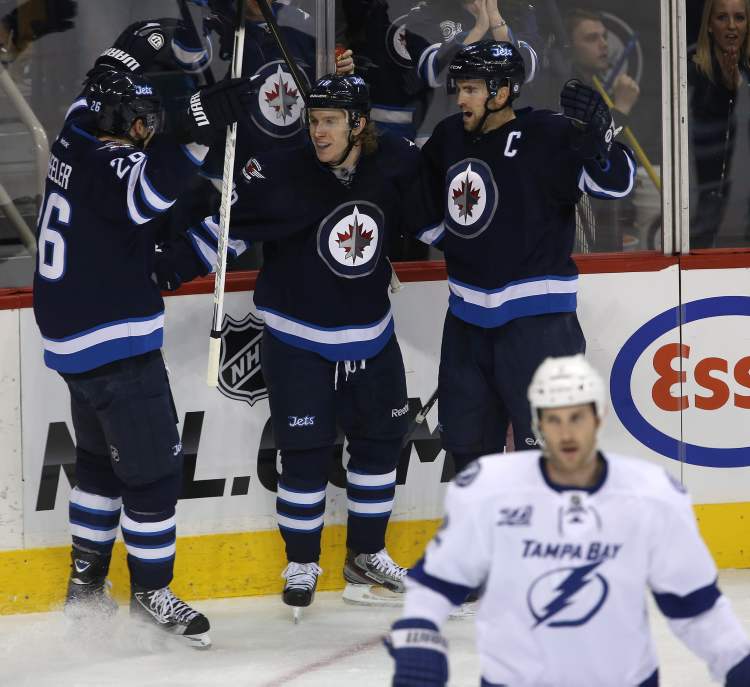 Trevor Hagan / THE CANADIAN PRESS
Winnipeg Jets Blake Wheeler, Bryan Little and Andrew Ladd (from left) celebrate after Little opened the scoring against the Tampa Bay Lightning during first-period NHL action in Winnipeg, Sunday.
