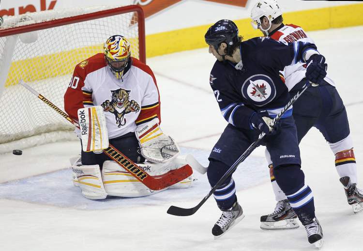 JOHN WOODS / THE CANADIAN PRESS
Winnipeg Jets forward Chris Thorburn scores against Florida Panthers goaltender Scott Clemmensen as TJ Brennan (3) defends during third-period NHL action in Winnipeg Thursday.