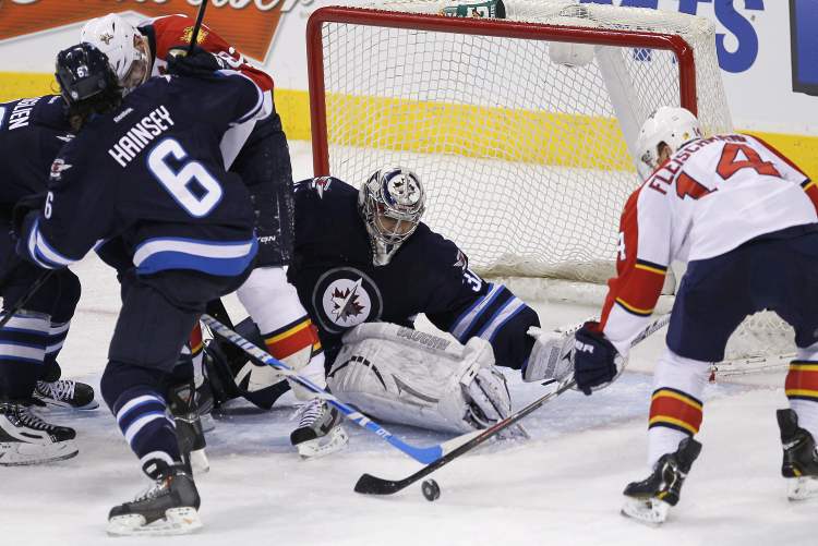 JOHN WOODS / THE CANADIAN PRESS
Florida Panthers' Tomas Fleischmann can't get the puck past Winnipeg Jets goaltender Ondrej Pavelec as Jets Dustin Byfuglien and Ron Hainsey take control of Panther Tomas Kopecky during the third period Thursday.