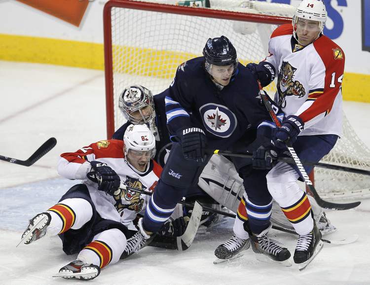 JOHN WOODS / THE CANADIAN PRESS
Winnipeg Jets defenceman Ron Hainsey deals with Florida Panthers Tomas Kopecky (left) and Tomas Fleischmann in front of Jets goaltender Ondrej Pavelec during third-period NHL action in Winnipeg Thursday.