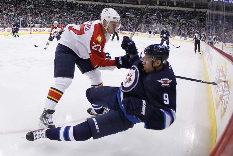 JOHN WOODS / THE CANADIAN PRESS
Florida Panthers' Nick Bjugstad checks Winnipeg Jets' Evander Kane during second-period NHL action in Winnipeg Thursday.
