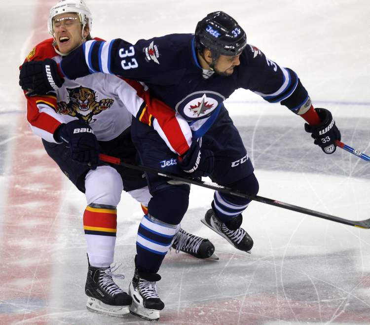 Phil Hossack / Winnipeg Free Press
Winnipeg Jets defenceman Dustin Byfuglien pushes Florida Panthers' Shawn Matthias aside as he moves the puck forward Thursday in first-period action.