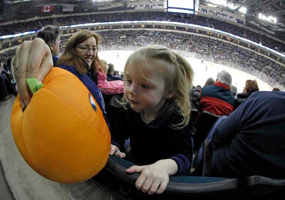 Trevor Hagan / Winnipeg Free Press
Gary and Kelly Depaulo brought their granddaughter, 21-month-old Jory Depaulo, to her first NHL hockey game. Kelly had to use other means to keep Jory entertained late in the third period as the Winnipeg Jets lost to the Columbus Blue Jackets at MTS Centre in Winnipeg Saturday.