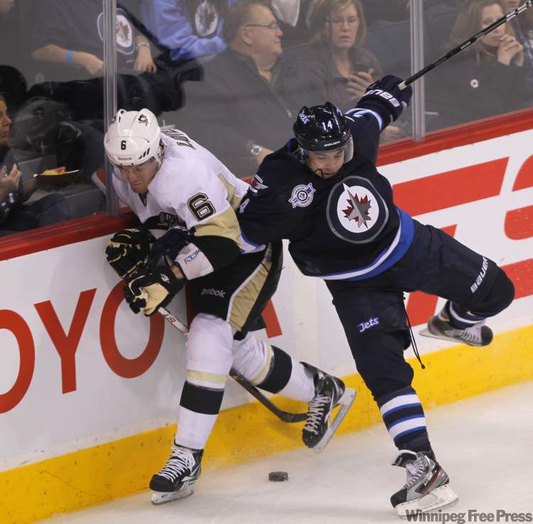 The Winnipeg Jets' Tim Stapleton and the Pittsburgh Penguins' Ben Lovejoy crash into the boards during second-period action. (Boris Minkevich / Winnipeg Free Press)