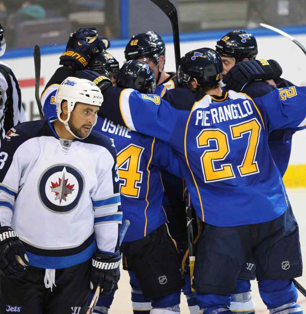 CP
St. Louis Blues' Alex Pietrangelo, T.J. Oshie, David Backes and Jay Bouwmeester surround teammate Alexander Steen after his game-winning goal as Winnipeg Jets defenceman Dustin Byfuglien skates away dejectedly.