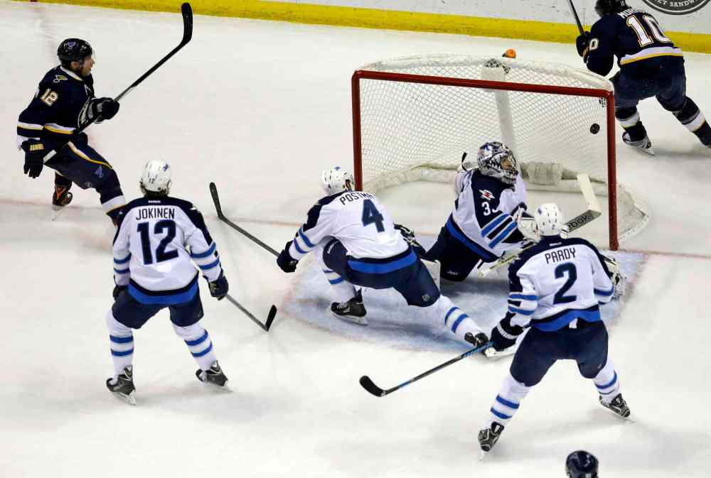Jeff Roberson / The Associated Press
St. Louis Blues' Derek Roy, left, scores a first-period goal past Winnipeg Jets' goalie Al Montoya as Olli Jokinen (12), Paul Postma (4) and Adam Pardy (2) look on.