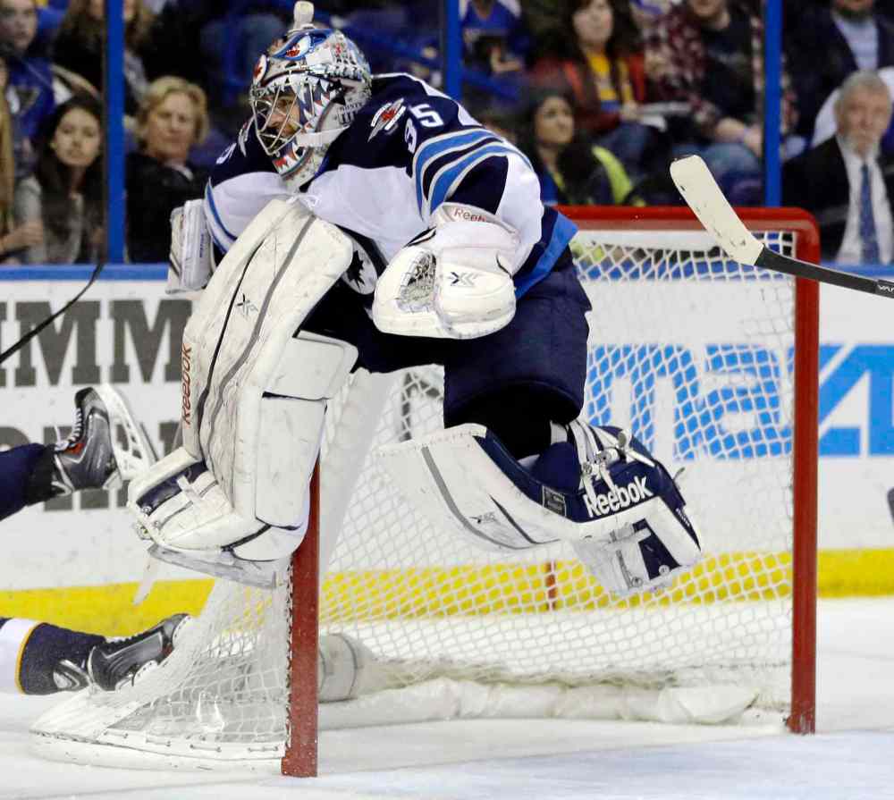 Jeff Roberson / The Associated Press
Winnipeg Jets goalie Al Montoya leaps into the air to avoid a sliding St. Louis Blues player during the second period of Saturday's NHL game in St. Louis.