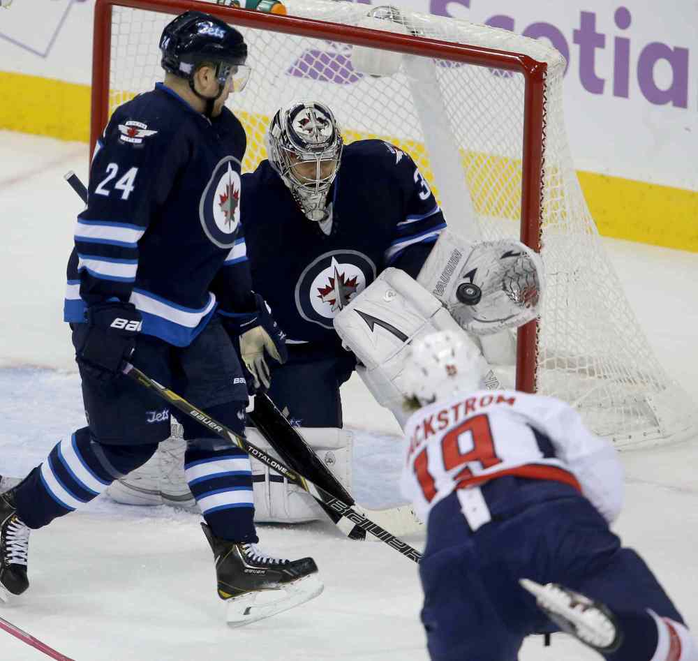 TREVOR HAGAN / THE CANADIAN PRESS
Winnipeg Jets goaltender Ondrej Pavelec makes a glove save on Washington Capitals' Nicklas Backstrom as Jets defenceman Grant Clitsome closes in.