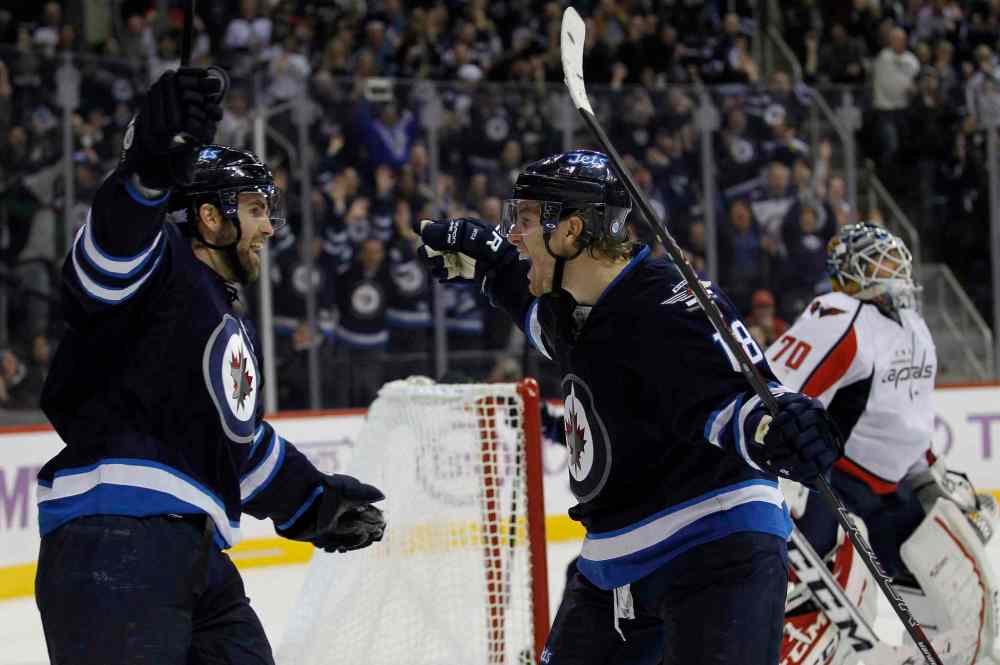 TREVOR HAGAN / THE CANADIAN PRESS
Winnipeg Jets captain Andrew Ladd (left) and teammate Bryan Little celebrate Little's goal against Washington Capitals goaltender Braden Holtby during the second period.