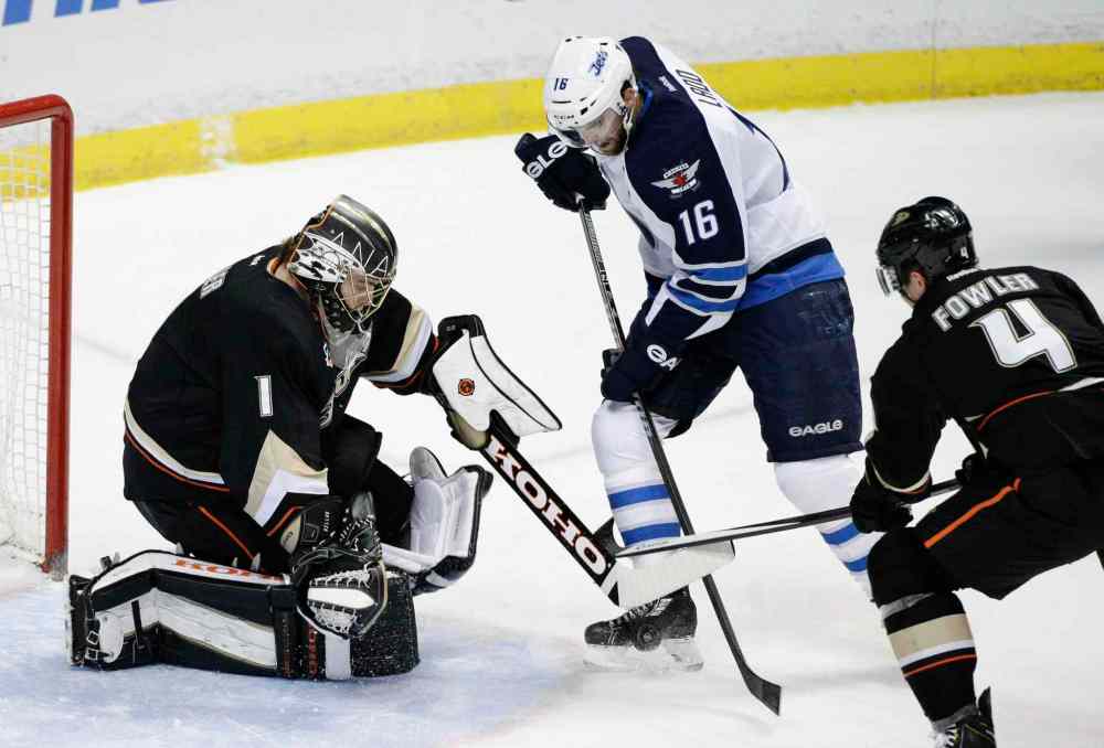 Jae C. Hong / The Associated Press
Winnipeg Jets' Andrew Ladd (16) tries to score against Anaheim Ducks' goalie Jonas Hiller, left, as the Ducks' Cam Fowler defends during first period in Anaheim Tuesday.