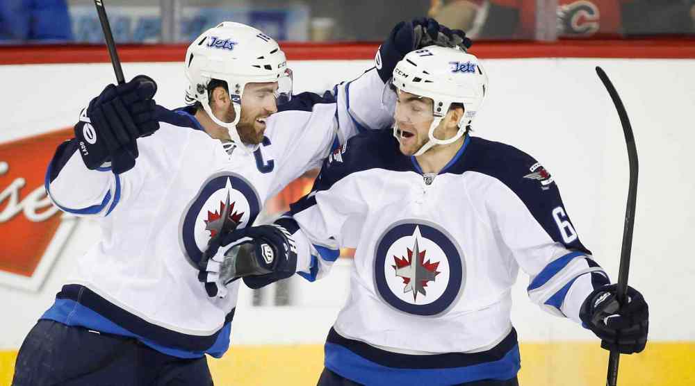 Jeff McIntosh / The Canadian Press
Winnipeg Jets' Michael Frolik, left, celebrates his assist with teammate Andrew Ladd during the game's first period against the Calgary Flames Thursday.
