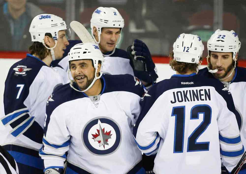Jeff McIntosh / The Canadian Press
Winnipeg Jets' Dustin Byfuglien, second from left, celebrates his goal with teammates during the first period against the Calgary Flames in Calgary.