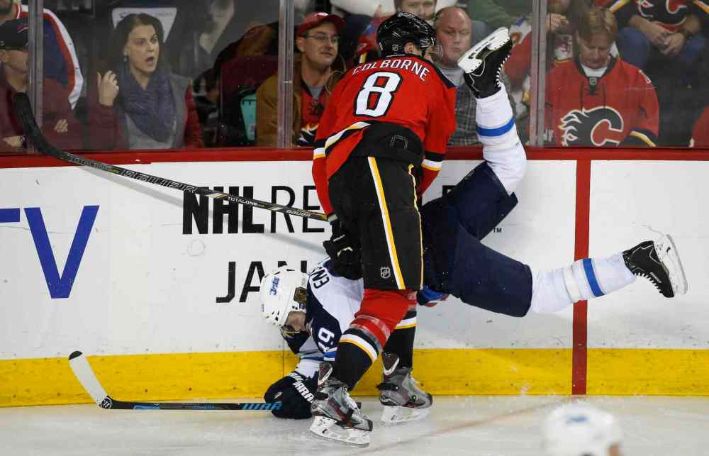 Jeff McIntosh / The Canadian Press
Winnipeg Jets' Tobias Enstrom, left, gets upended by Calgary Flames' Joe Colborne during third period in Calgary Thursday.