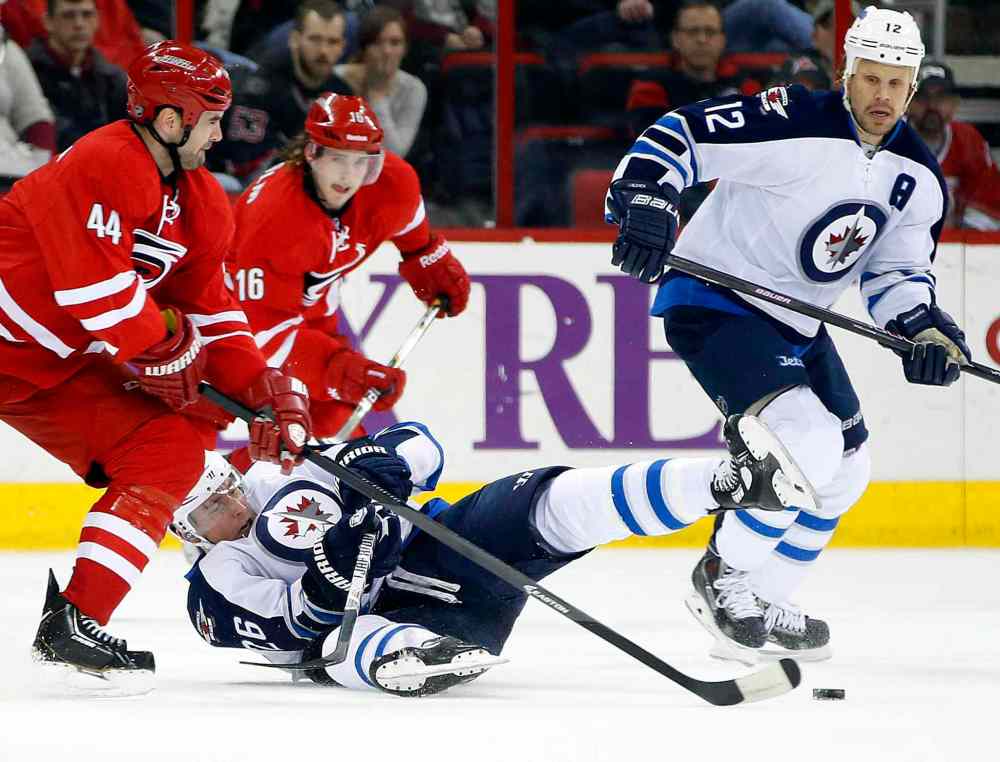 Karl B DeBlaker / The Associated Press
Carolina Hurricanes' Jay Harrison (44) takes Winnipeg Jets' Blake Wheeler (26) off the puck with Olli Jokinen (12) of Finland, during the first period of an NHL hockey game in Raleigh, N.C. on Tuesday.