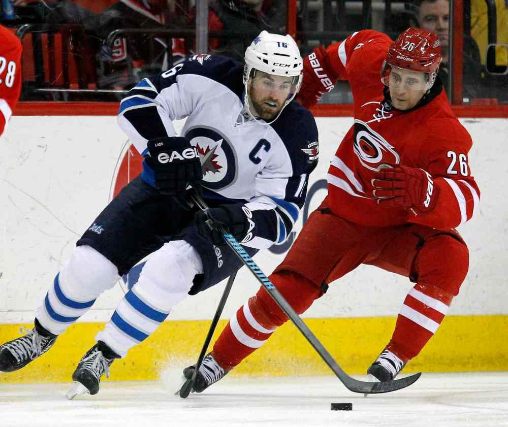 Chris Seward / Raleigh News & Observer/ Tribune Media MCT
Winnipeg Jets' Andrew Ladd (16) works against Carolina Hurricanes' John-Michael Liles (26) during the first period at the PNC Arena in Raleigh, N.C. on Tuesday.