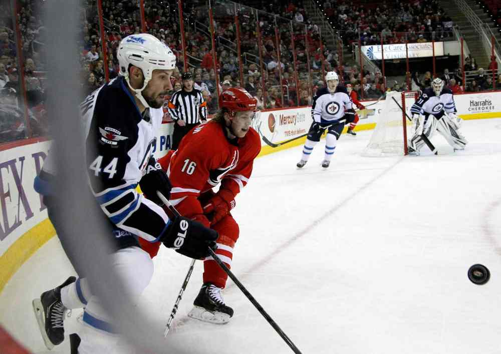 Chris Seward / Raleigh News & Observer/ Tribune Media MCT
Winnipeg Jets' Zach Bogosian (44) and Carolina Hurricanes' Elias Lindholm (16) go for the puck during the first period at the PNC Arena in Raleigh, N.C., on Tuesday.