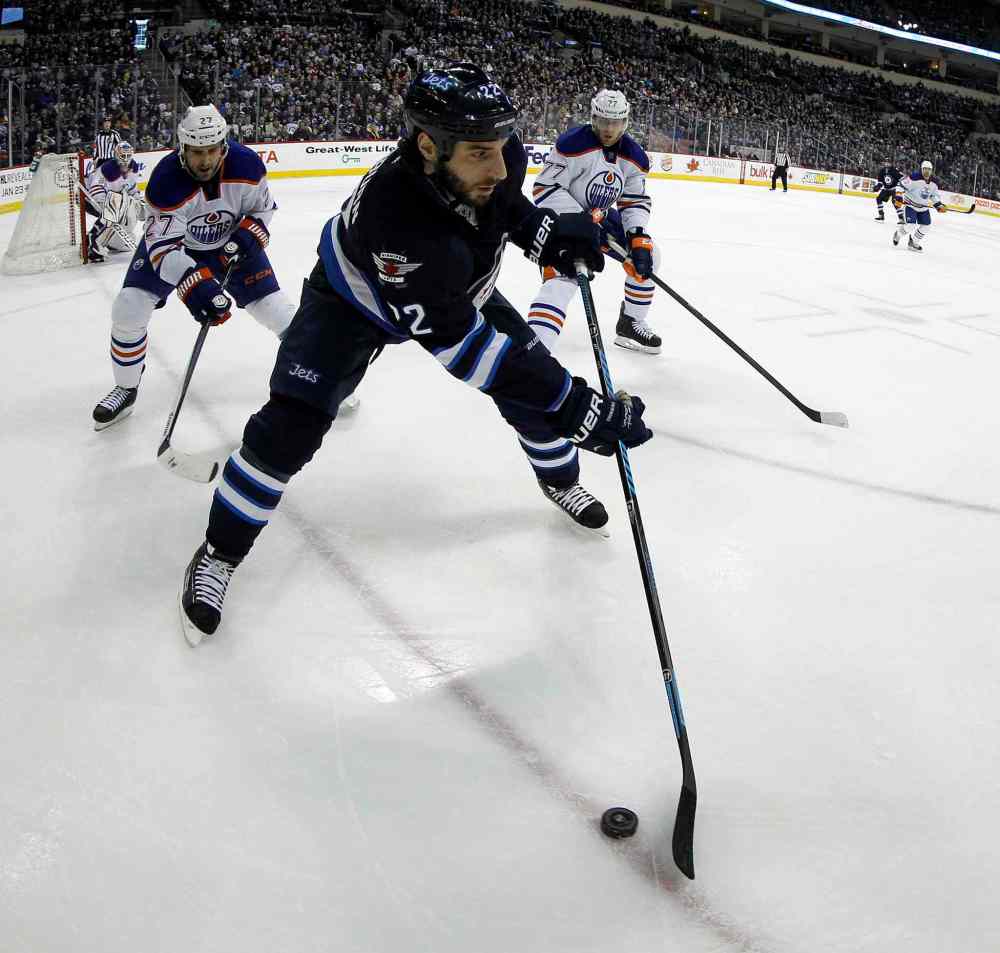 TREVOR HAGAN/WINNIPEG FREE PRESS
Winnipeg Jets' Chris Thorburn (22) carries the puck in front of Edmonton Oilers' Boyd Gordon (27) and Anton Belov (77) during second period in Winnipeg Saturday.