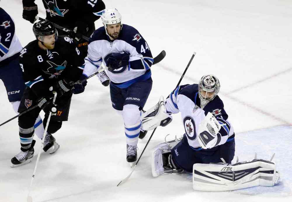 Marcio Jose Sanchez / The Associated Press
Winnipeg Jets' goalie Ondrej Pavelec, right, stops a shot next to teammate Zach Bogosian (44) and San Jose Sharks' Joe Pavelski (8) during the first period of Thursday's game.