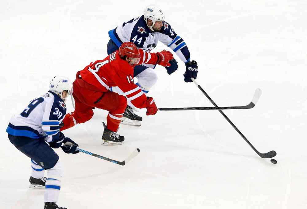 Karl B DeBlaker / The Associated Press
Carolina Hurricanes' Nathan Gerbe (14) tries to split the defense of Winnipeg Jets' Zach Bogosian (44) and Tobias Enstrom (39) of Sweden, during the third period of Tuesday's game.