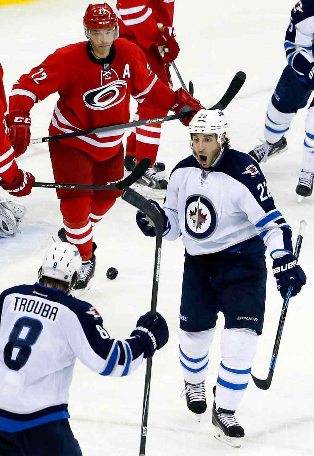 Karl B DeBlaker / The Associated Press
Winnipeg Jets' Chris Thorburn (22) celebrates his go-ahead goal with teammate Jacob Trouba (8) as Carolina Hurricanes' Manny Malhotra (22) looks on during the third period of Tuesday's game.