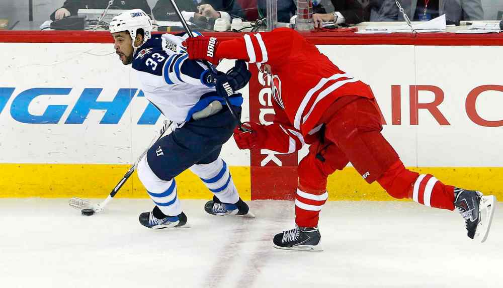 Karl B DeBlaker / The Associated Press
Winnipeg Jets' Dustin Byfuglien (33) avoids a check from Carolina Hurricanes' Tuomo Ruutu (15) during the third period of Tuesday's game in Raleigh.
