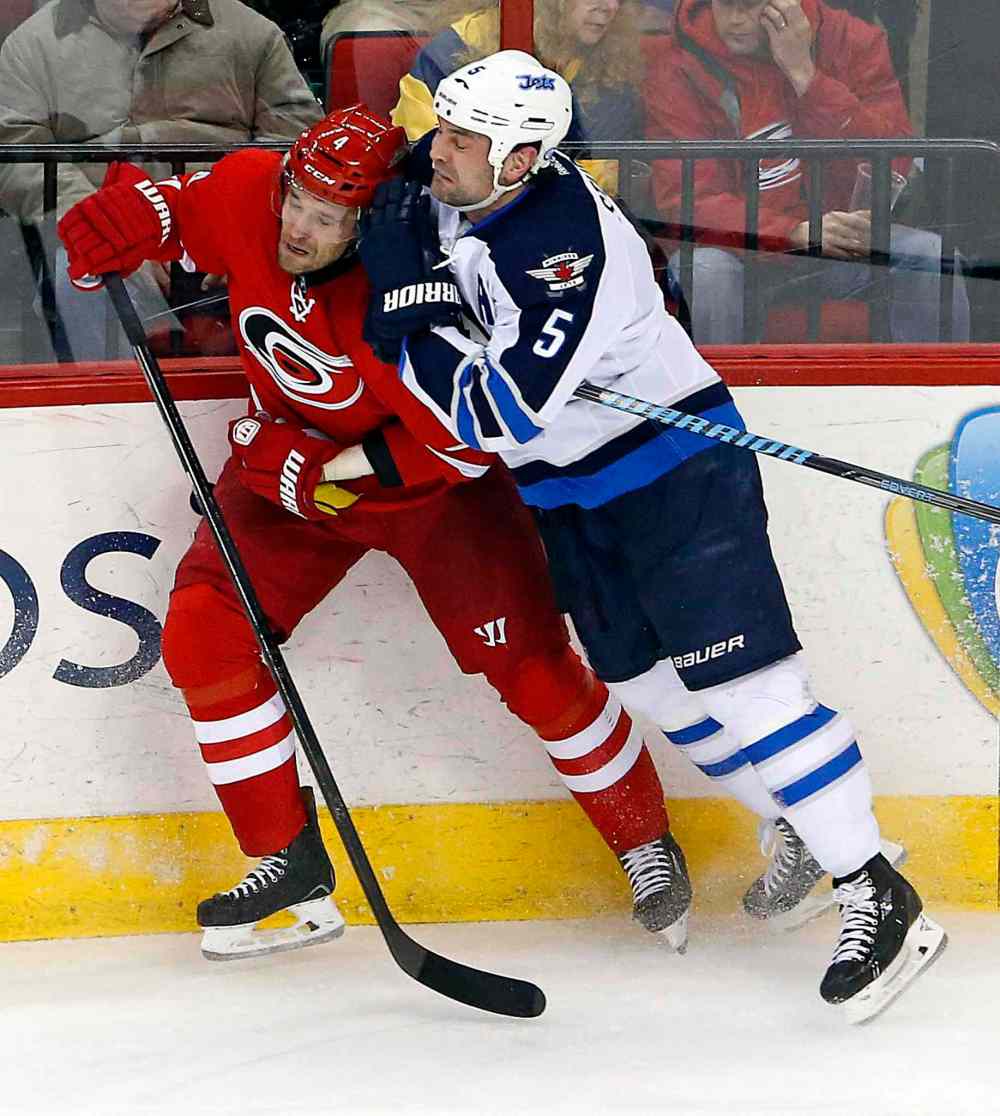 Karl B DeBlaker / The Associated Press
Winnipeg Jets' Mark Stuart (5) checks Carolina Hurricanes' Andrej Sekera (4) into the boards during the third period of Tuesday's game.