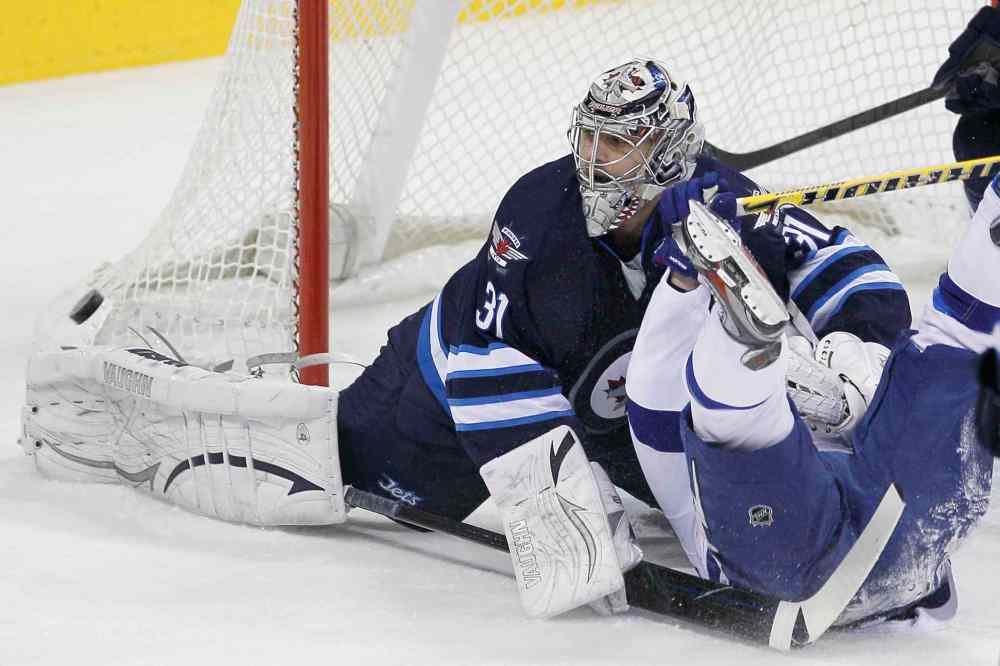 John Woods / Winnipeg Free Press
Winnipeg Jets' goaltender Ondrej Pavelec (31) saves the shot as he gets tangled up with Tampa Bay Lightning's Martin St. Louis (26) during first period NHL action in Winnipeg Tuesday.