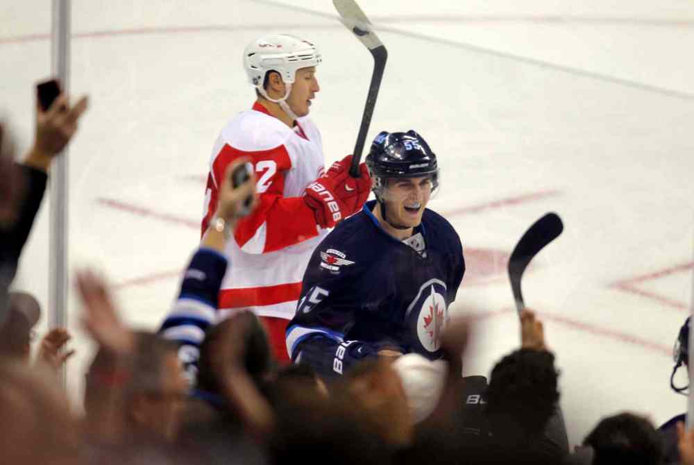 BORIS MINKEVICH / WINNIPEG FREE PRESS
Winnipeg Jets forward Mark Scheifele celebrates teammate Michael Frolik's second-period goal as Detroit Red Wings forward Jordan Tootoo skates by.