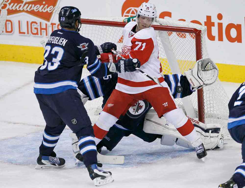 JOHN WOODS / THE CANADIAN PRESS
Winnipeg Jets goaltender Al Montoya stops the puck as Jets defenceman Dustin Byfuglien attempts to clear Detroit Red Wings forward Daniel Cleary from the front of the net during the first period.