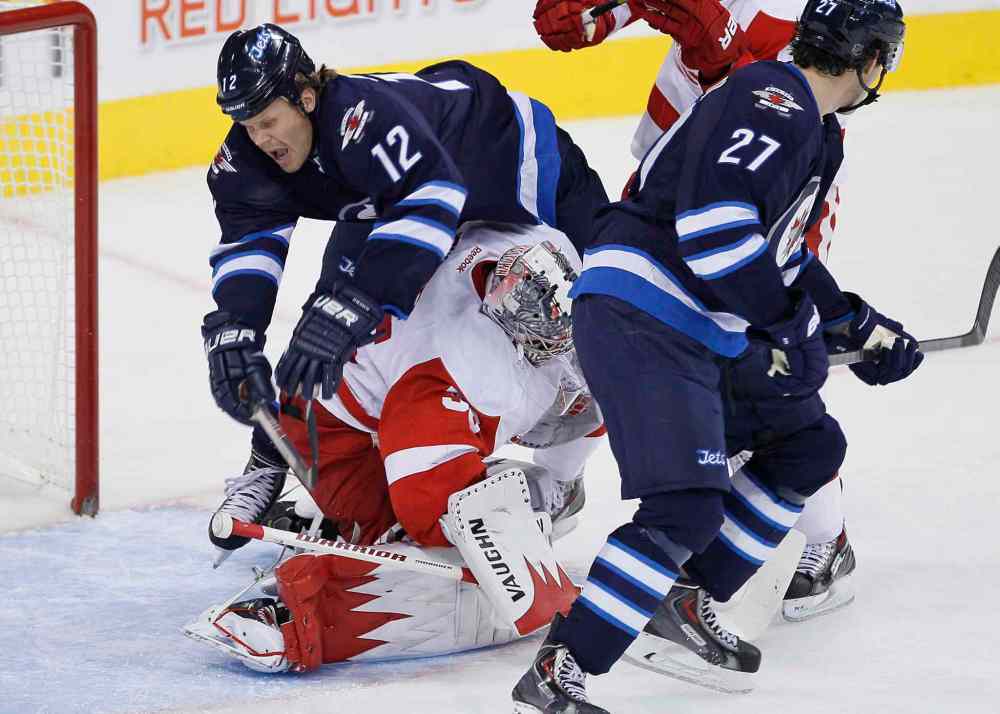 JOHN WOODS / THE CANADIAN PRESS
Winnipeg Jets forward Olli Jokinen goes over the top of Detroit Red Wings goaltender Jimmy Howard in the first period.