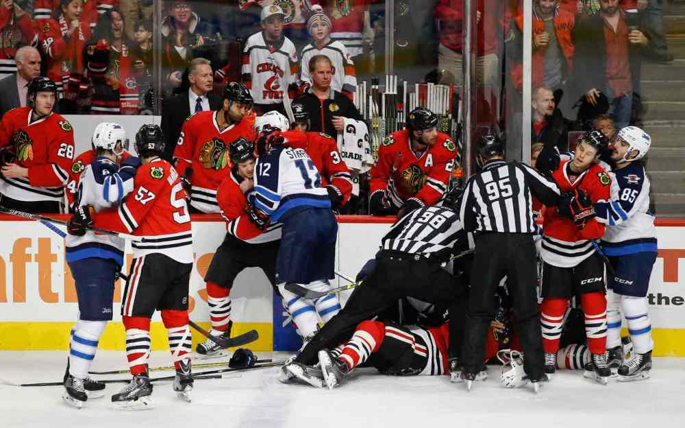 Kamil Krzaczynski / The Associated Press
Chicago Blackhawks fight with Winnipeg Jets players during the first period of Sunday's game.