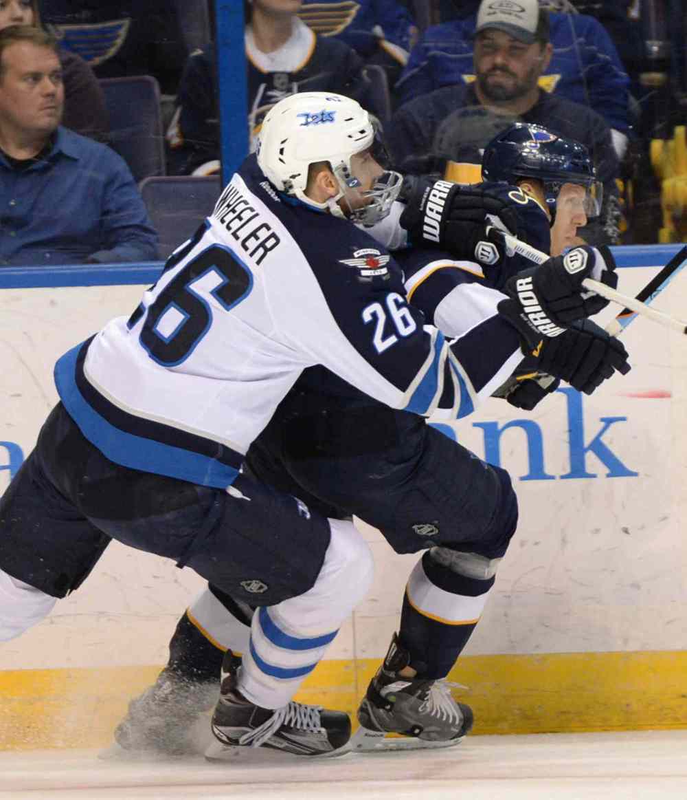 Bill Boyce / The Associated Press
St. Louis Blues' Carl Gunnarsson (4), right, is checked by Winnipeg Jets' Blake Wheeler (26) during the first period of Tuesday's game.