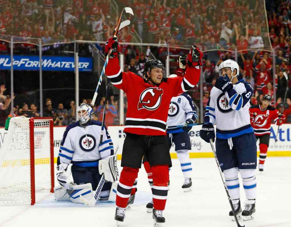 Rich Schultz / The Associated Press
New Jersey Devils forward Jiri Tlusty, front left, of the Czech Republic, celebrates his goal past Winnipeg Jets goalie Michael Hutchinson as center Alex Burmistrov (6), of Russia, looks back.