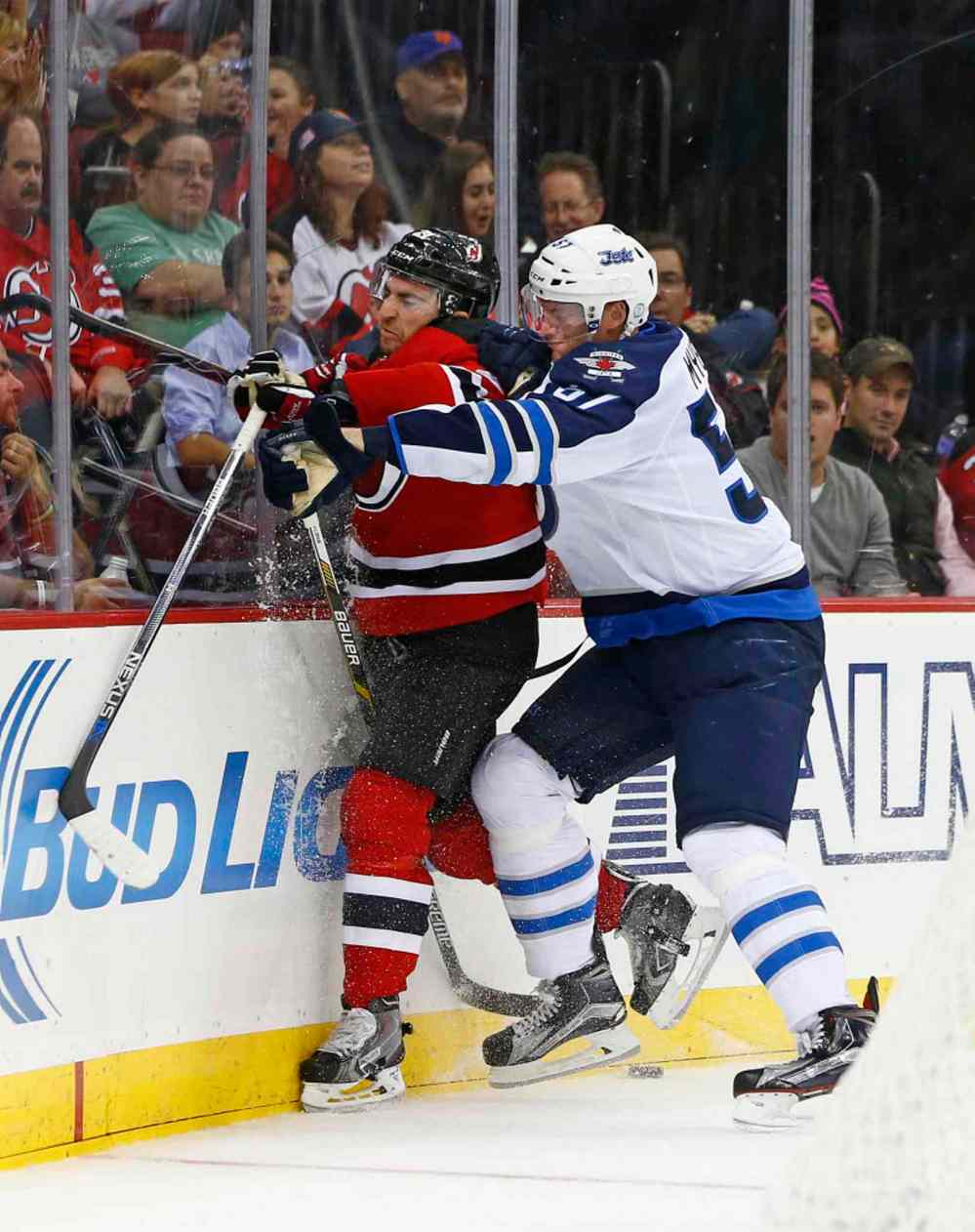 Rich Schultz / The Associated Press
New Jersey Devils center Kyle Palmieri (left) is checked off the puck by Winnipeg Jets defensemen Tyler Myers (57).