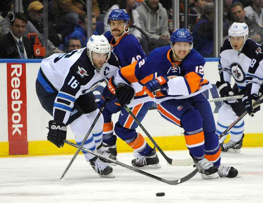 Kathy Kmonicek / The Associated Press
Winnipeg Jets captain Andrew Ladd (left) cuts in on New York Islanders forward Josh Bailey (centre right) in the second period.