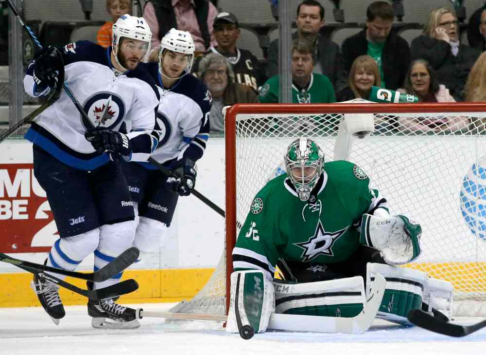 Tony Gutierrez / The Associated Press
Dallas Stars goalie Kari Lehtonen (right) makes a stop as Winnipeg Jets forwards Anthony Peluso (left) and Michael Frolik track the puck during the first period of Saturday night's game in Dallas.