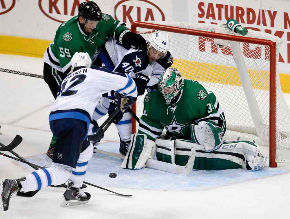 Tony Gutierrez / The Associated Press
Olli Jokinen attempts a shot on a rebound against Dallas Stars goalie Kari Lehtonen as defenceman Sergei Gonchar grapples with Devin Setoguchi in front of the net during overtime.