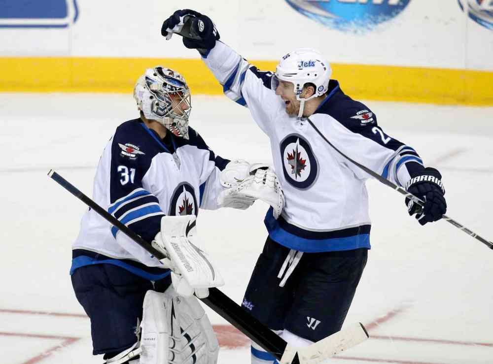 Tony Gutierrez / The Associated Press
Ondrej Pavelec celebrates with Blake Wheeler after a shootout.